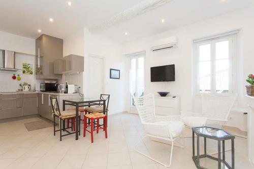 戛纳Mont Chevalier by Welcome to Cannes的厨房以及带桌椅的起居室。