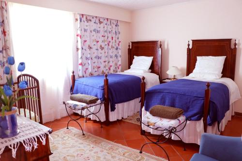 丰沙尔Casa Charmosa的蓝色和白色的客房内的两张床