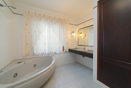 普拉亚布兰卡Villa Victoria的白色的浴室设有浴缸和水槽。
