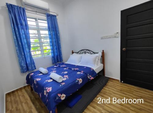 Gemia Rumah Tamu - 3 bilik aircond - near nasi dagang Atas tol的一间卧室配有一张带蓝色床单的床和一扇窗户。