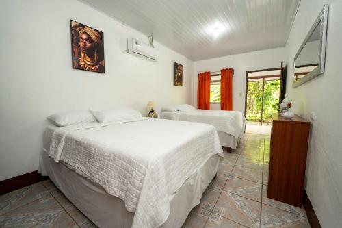 托尔图格罗Hotel Tortuguero Beachfront的一间卧室设有两张床和窗户。