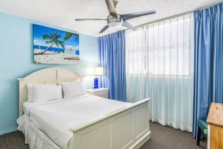 基韦斯特The Trinidad by Brightwild-Pool & Parking的一间卧室配有一张蓝色墙壁的床和吊扇