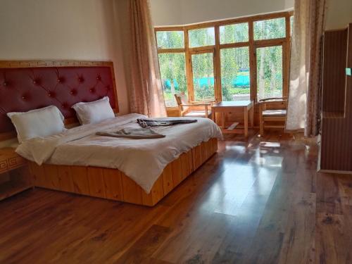 列城Zee Guest House的一间卧室配有一张大床和红色床头板