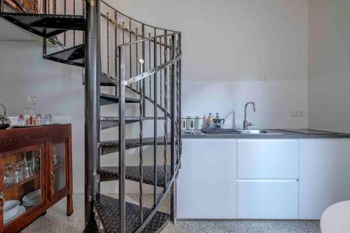 拉文纳La Casetta nel Cerchio的水槽旁厨房的螺旋楼梯