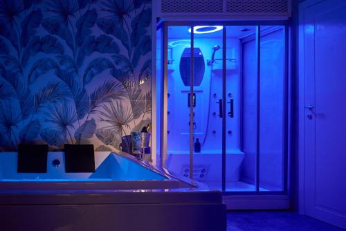 莱切Bobò Suite的一间带浴缸的浴室,位于蓝色灯光的房间