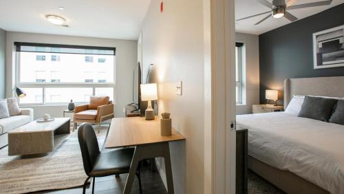 纽波特Landing Modern Apartment with Amazing Amenities (ID7744X77)的一间卧室配有一张床、一张桌子和一张床,还设有一间客厅。
