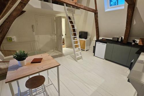 阿拉斯Le perchoir, studio avec mezzanine的厨房配有木桌和梯子