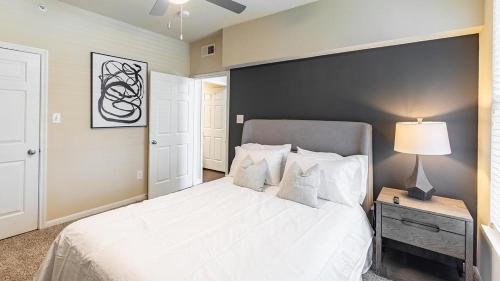 理查森Landing Modern Apartment with Amazing Amenities (ID6588X72)的卧室配有一张白色的床和黑色的墙壁