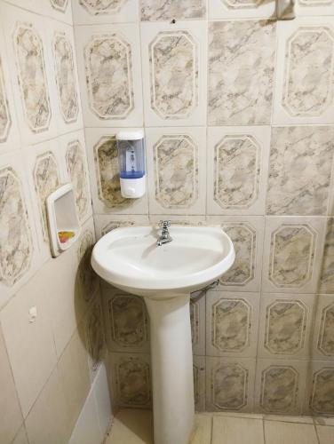 LuqueMangoty Apartamento的浴室铺有大理石瓷砖,配有白色水槽。