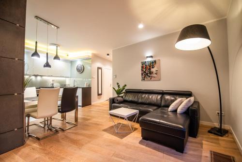 克拉科夫City Lights Apartments的客厅配有真皮沙发和桌子