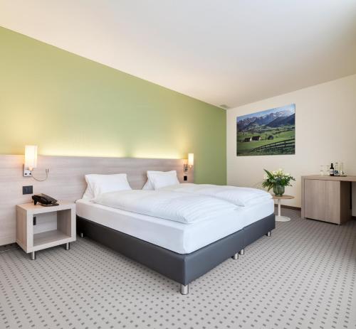 圣加仑Hotel Eastside (free parking garage)的一间卧室设有一张大床和绿色的墙壁