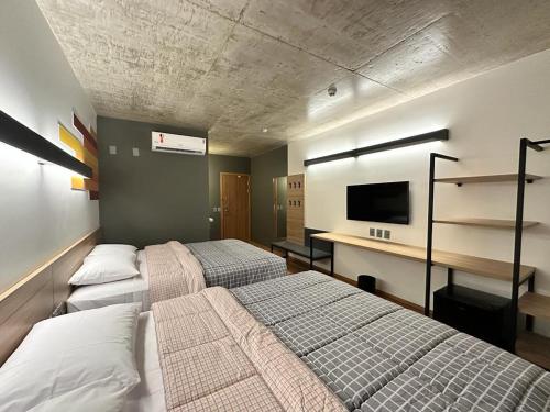 索里苏Hotel 10 Sorriso的一间卧室配有两张床和一张书桌及电视