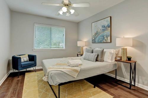 休斯顿Artsy Home, Sleeps 9, Mins to Bellaire & Galleria的一间卧室配有一张床和一张蓝色椅子