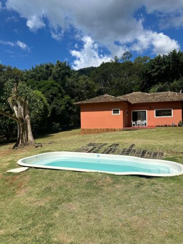 彼得罗波利斯Casa aconchego Secretário的一座大游泳池,位于房子前面的庭院内