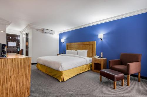 托卢卡Radisson Hotel & Convention Center Toluca的配有一张床和一把椅子的酒店客房