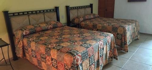 恰卡拉HOTEL PARAISO ESCONDIDO的一间带两张床的卧室,铺有瓷砖地板。