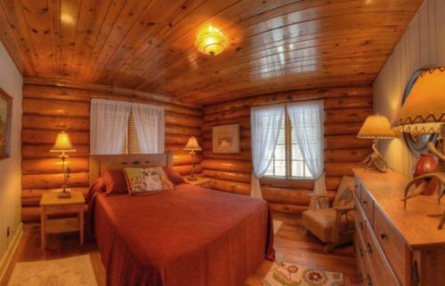 拉皮德城Historic Log Cabin #14 at Horse Creek Resort的小木屋内一间卧室,配有一张床