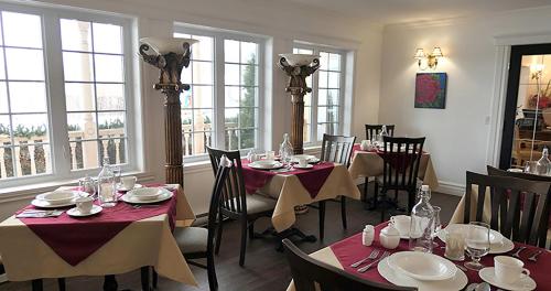 拜圣保罗Auberge La Daïna的用餐室设有桌椅和窗户。