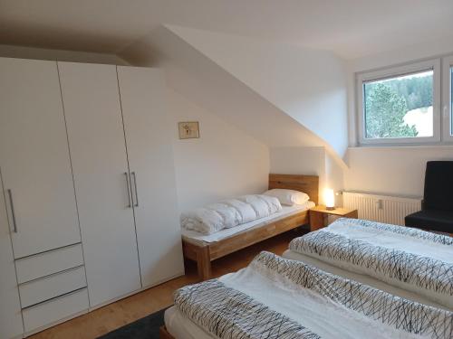 申瓦尔德Haus Lucia, mit Pool und Sauna, Appartment 4的阁楼卧室设有两张床和窗户。