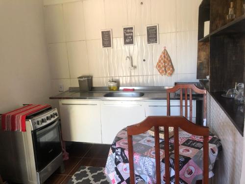 里约热内卢Apartamento aconchegante com deck的厨房配有炉灶、水槽和2把椅子