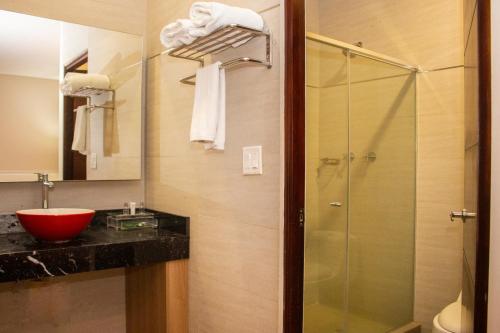巴拿马城Ramada by Wyndham Panama Via Argentina的一间带玻璃淋浴和水槽的浴室