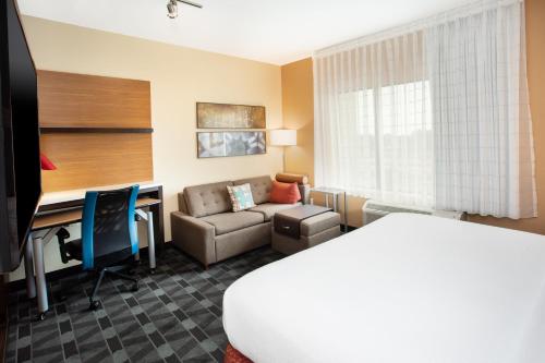 贝尔维尔TownePlace Suites by Marriott Detroit Belleville的配有一张床和一张书桌的酒店客房