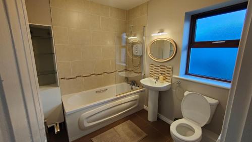 基尔科克Spacious 3 bedroom home的浴室配有卫生间、盥洗盆和浴缸。
