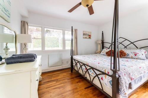 格林波特Greenport village cottage w/ 4 bedrooms的一间卧室配有一张床和吊扇