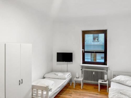 萨尔布吕肯CityChalet Monteur Apartments的白色的客房设有两张床和窗户。