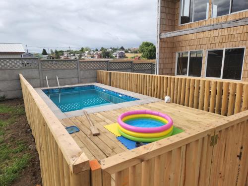 琼奇Cabaña Loft del Sur Premium的木制甲板上配有两个充气玩具的游泳池