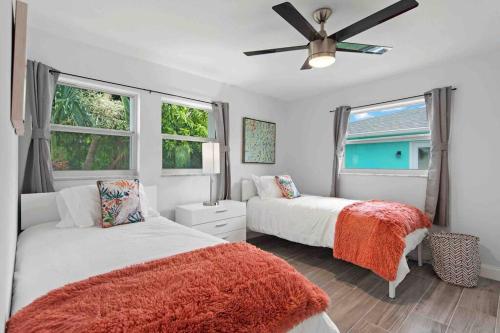 珊瑚角Newly Renovated 3 Room Home w/Heated Pool的一间卧室配有两张床和吊扇