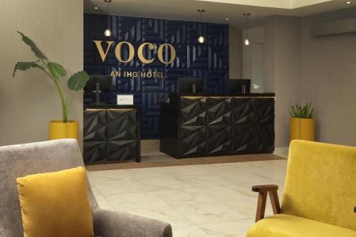萨尔蒂约voco Saltillo Suites, an IHG Hotel的大堂设有两把椅子和瑜伽标志