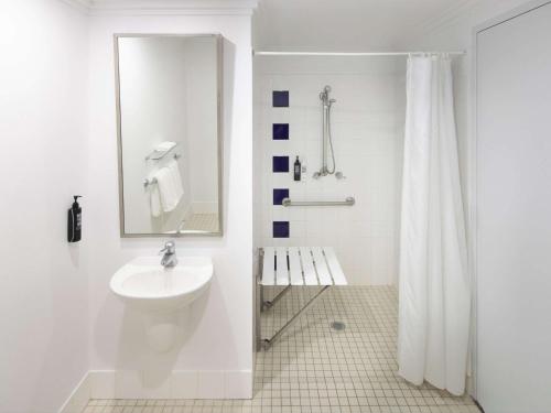 悉尼ibis Styles Sydney Central的白色的浴室设有水槽和淋浴。