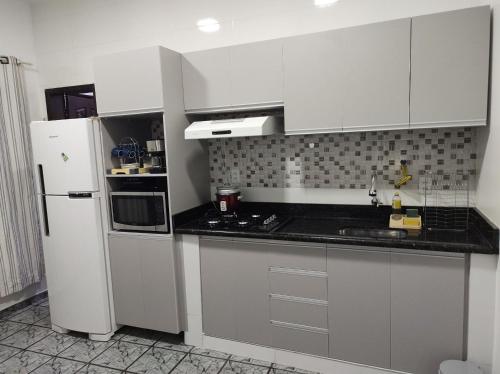 卡夸尔Apartamentos aconchegantes no centro da cidade的厨房配有白色橱柜和白色冰箱。