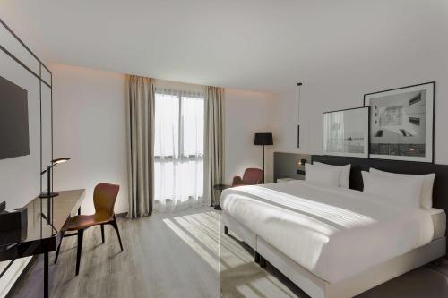 突尼斯Radisson Hotel Tunis, City Center的酒店客房设有一张大床和一张书桌。