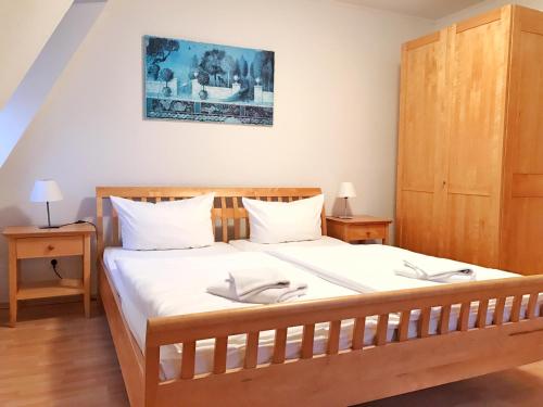 布雷格Hafenhäuser Breege - Ferienwohnung 18 - Ankerplatz的一间卧室配有一张大木床和白色床单