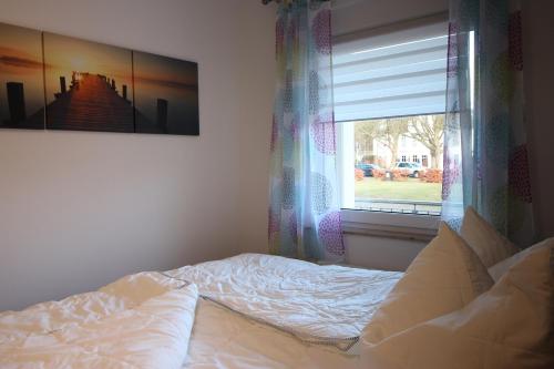 朱列斯拉赫Kurparkcarree - Ferienwohnung Meeresbrise的卧室内的一张床铺,带窗户