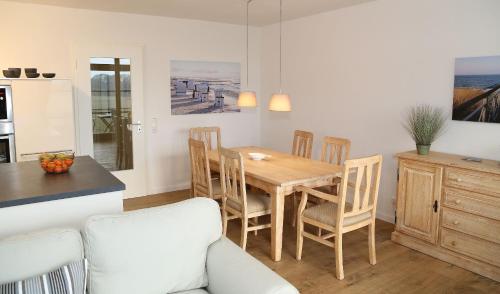 维滕贝克Ferienwohnung Sonnenblick的厨房以及带木桌和椅子的用餐室。