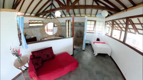 Opoa法尔欧碧日旅舍的客厅配有红色的沙发和镜子
