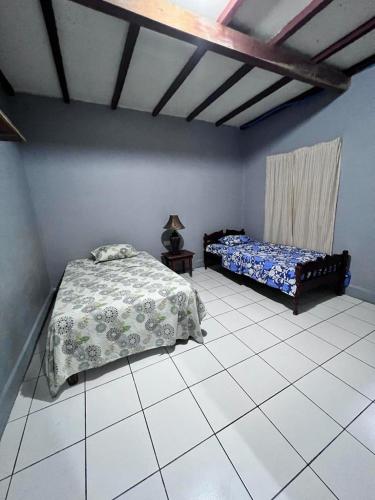 TamaniqueHotel Pacific Surf with AC Best Room In Tunco Beach的一间带两张床的卧室,铺有瓷砖地板。