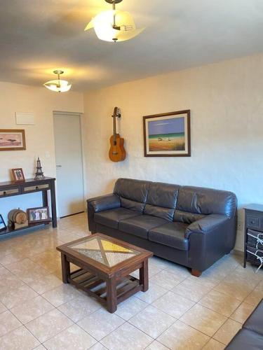 梅塞德斯Casa de dos plantas的客厅配有真皮沙发和茶几