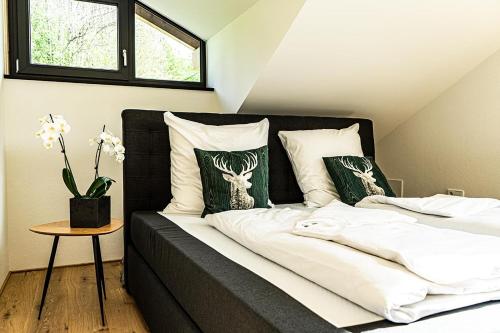 上施陶芬Alpenloft Ausblick的一张带白色床单和绿色枕头的床