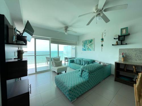 通苏帕Resort Playa Azul 3 Dormitorios的带沙发和电视的客厅以及海洋