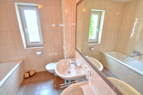 巴德加斯坦Apartment Dunn - by Alpen Apartments的浴室配有盥洗盆、卫生间和浴缸。