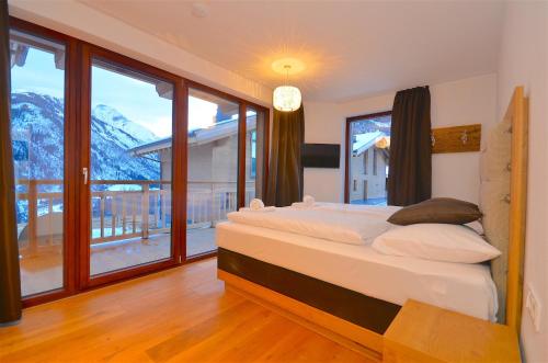 卡普伦Ski-in Ski-out Chalet Maiskogel 13B - by Alpen Apartments的一间卧室设有一张床和一个大窗户