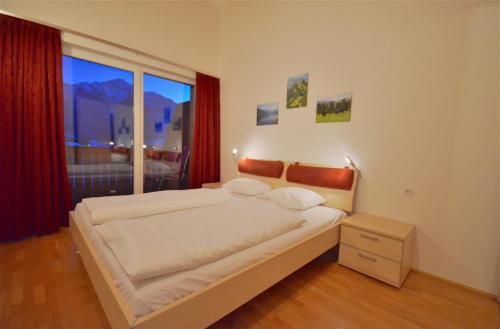滨湖采尔APT Mountain View by - Alpen Apartments的一间卧室设有一张大床和一个大窗户