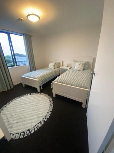 奥克兰Mountain View的一间卧室设有两张床和窗户。