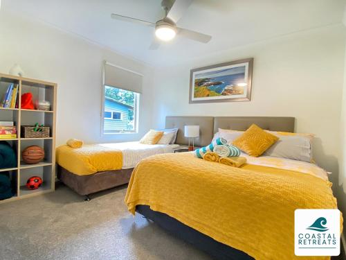 卡尔斯Woodland Retreat - Phillip Island - Ramada Resort的一间卧室配有两张带黄床单的床