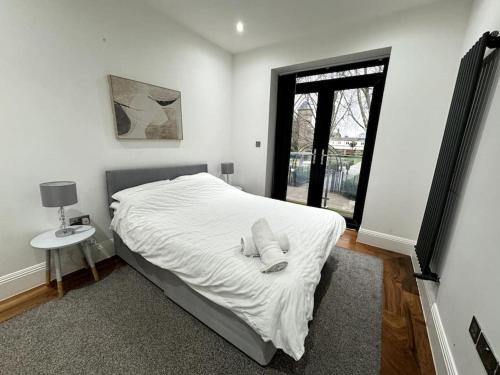 伦敦Modern Majesty 3 Bed 3 Bath House in London的卧室配有白色的床和窗户。