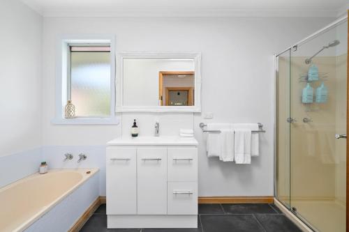 斯坦利LuCo House Stanley的白色的浴室设有浴缸和水槽。